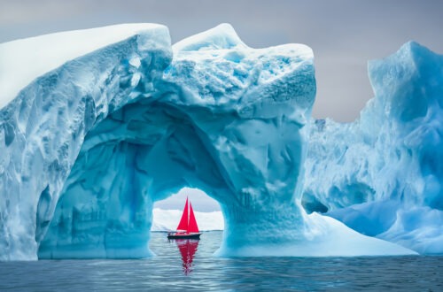 voilier naviguant dans le Grand Nord devant un iceberg
